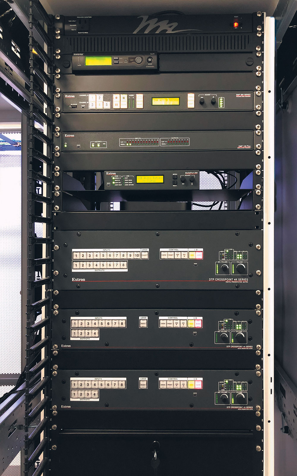 SMP 351 streaming media processor (top of rack) allows classroom training sessions to be broadcast to remote locations or recorded for video on demand. DTP CrossPoint 4K presentation matrix switchers (middle of rack) provide 4K switching and scaling, as well as integrated control processing and audio amplification.