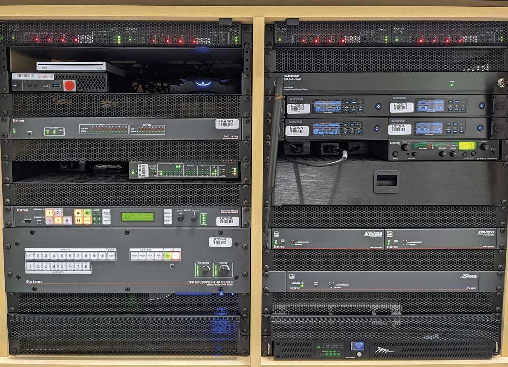 The left side of the Gant lecture hall teaching station houses AV sources, switching, distribution, streaming, and control equipment as well as a digital matrix processor for mixing and processing audio. The right side contains wireless mic receivers and audio amplifiers.