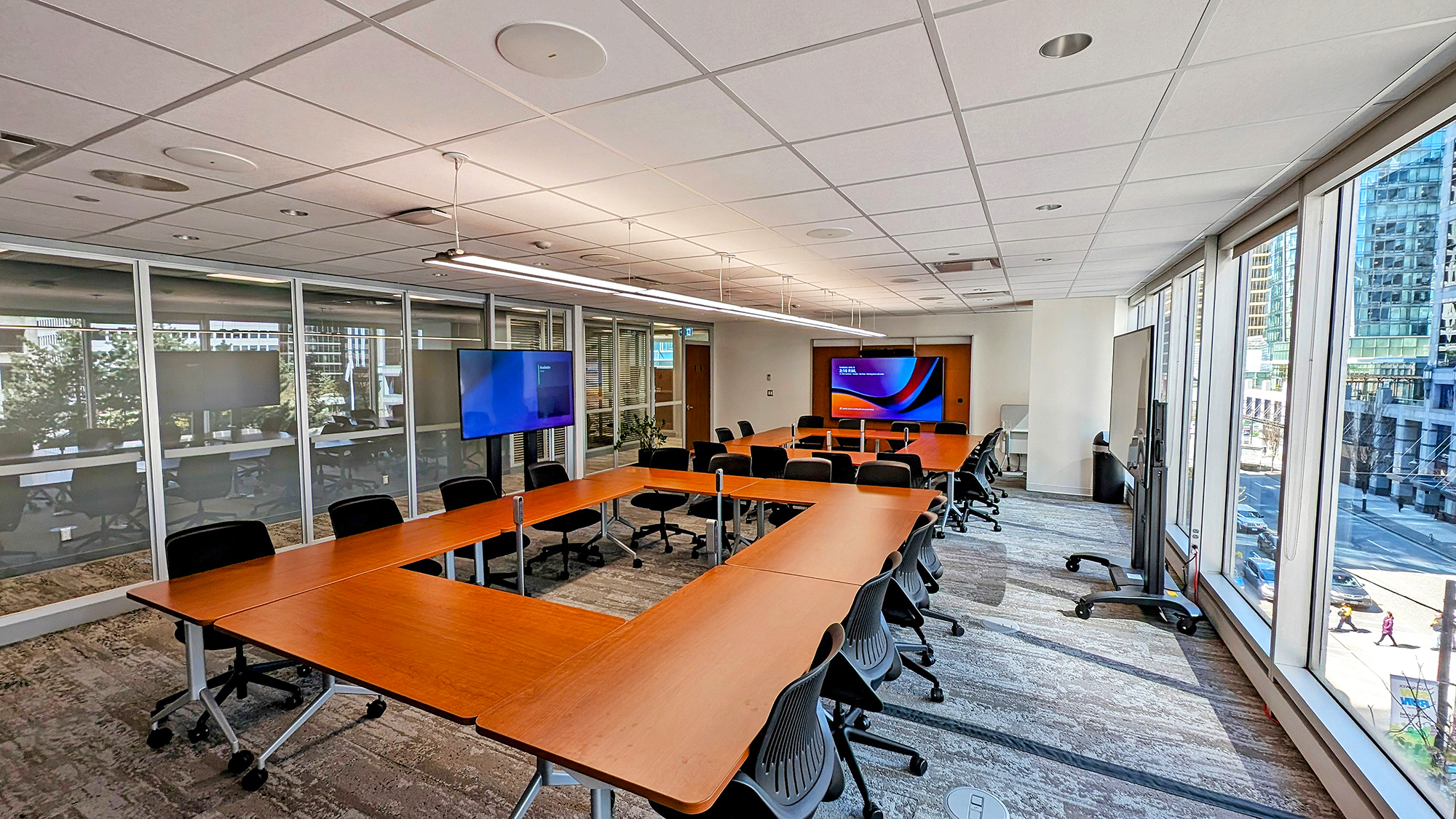 The room’s design allows for easy reconfiguration, with movable displays and flexible seating arrangements to accommodate different types of meetings and training sessions.