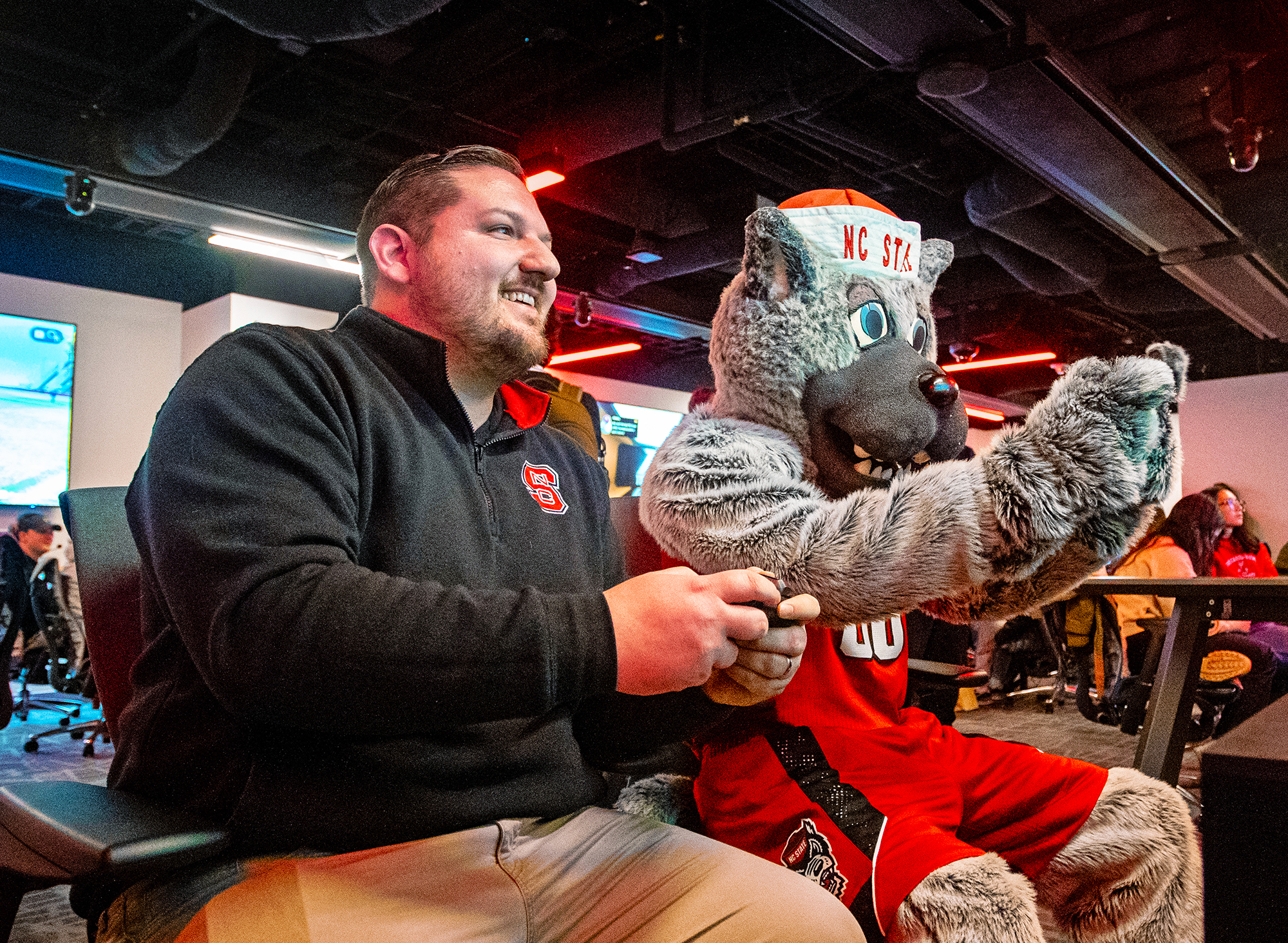 NC State Esports Program Director Cody Elsen enjoys a friendly game with the school's mascot, Mr. Wuf.