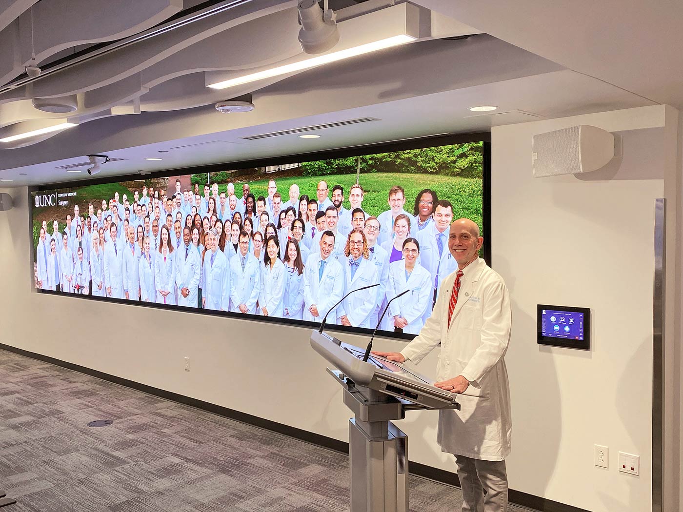 The AV system and room lighting are controlled at the wall-mounted TouchLink Pro touchpanel. Presenters advance and annotate their slides at the smart lectern. Photo courtesy of Heidi Grassley, ClarkPowell.