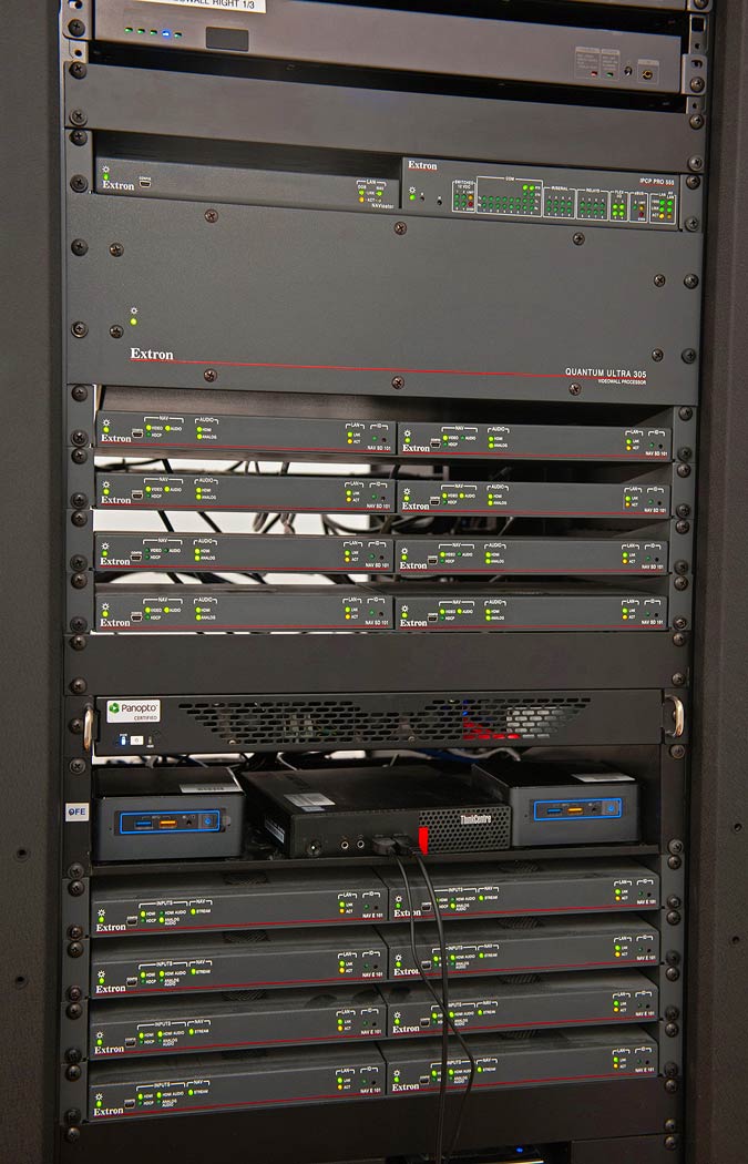 The Control Room rack contains NAV Pro encoders, decoders, and NAVigator, as well as the Quantum Ultra videowall processor, IPCP Pro control processor, and various AV content sources.